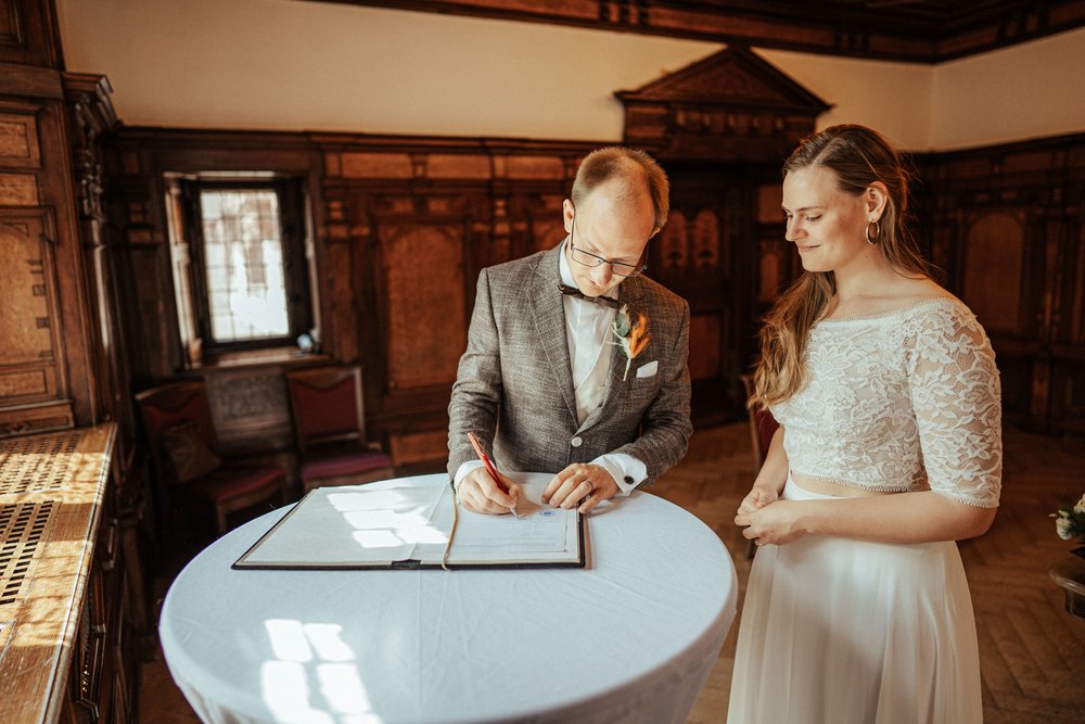 Unterschrift im Standesamt Freiburg Alter Ratssaal by UhlArt Fotografie