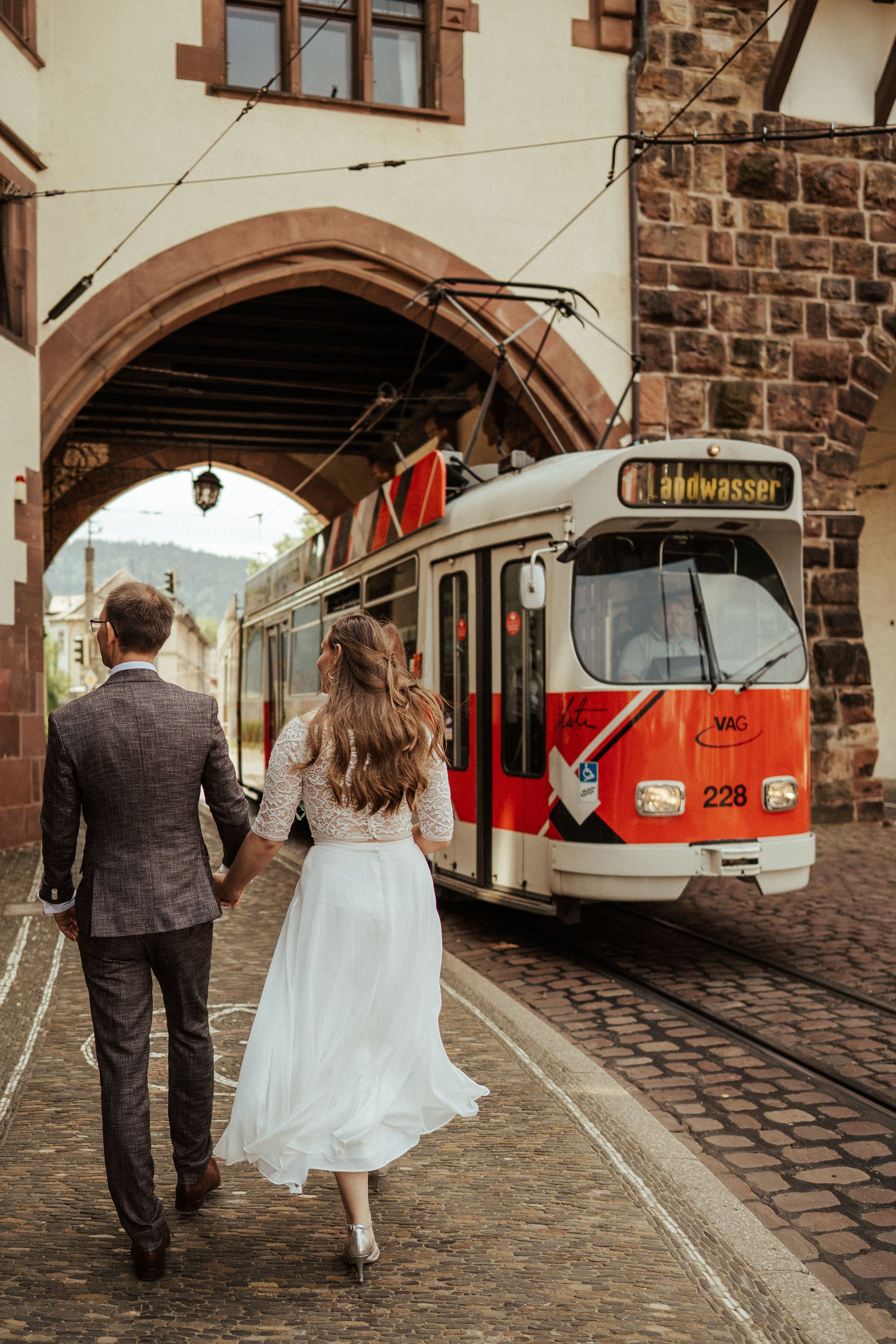 Brautpaar am Schwabentor mit roter alter Straßenbahn in Freiburg 