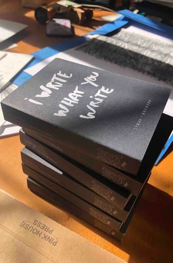 A stack of black books titled "i WRITE WHAT YOU WRITE" by Pink House Press, featured by Until Sunday Studio's Creative Exchange.