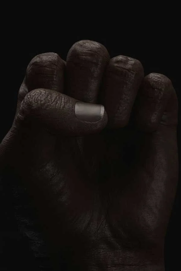 A dramatic close-up photograph of a clenched fist representing the Carob platform, featured by Until Sunday Studio's Creative Exchange.