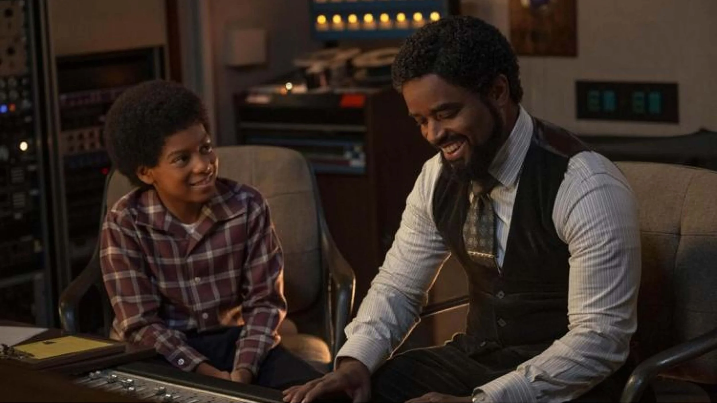 Michael. the movie. Young Michael Jackson sitting at a recording studio console with producer Berry Gordy, learning the controls, in a scene from the 2025 Michael biopic.
