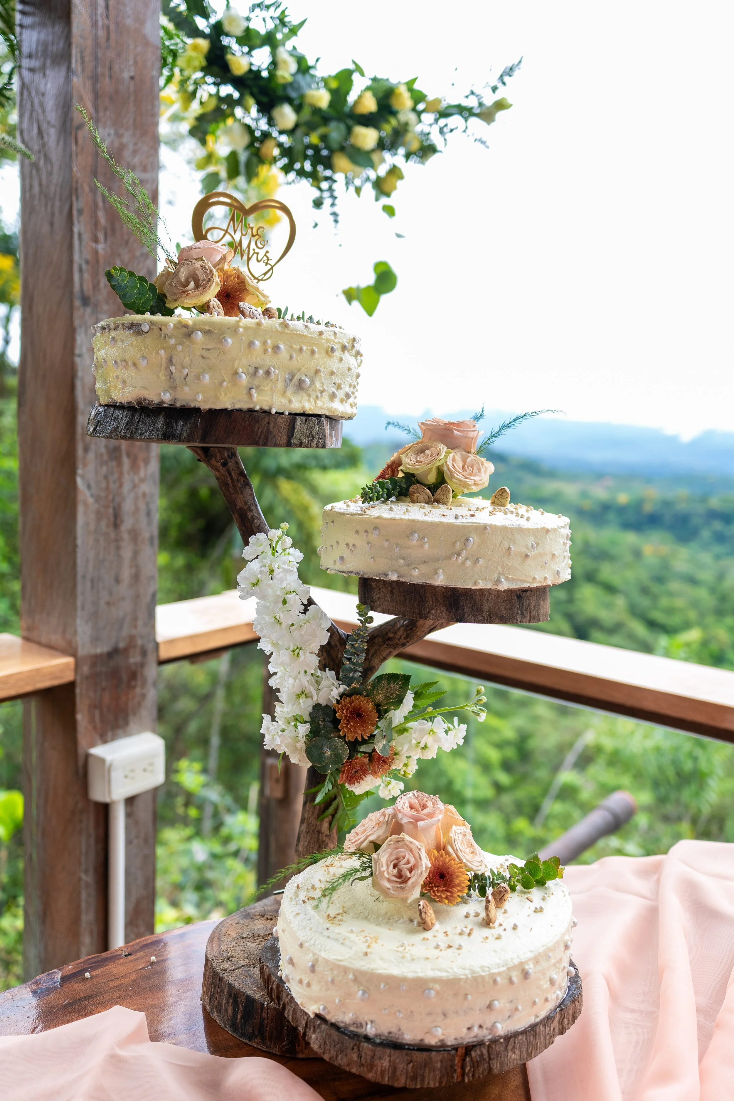 Tarta de boda con flores decoradas en un entorno al aire libre.