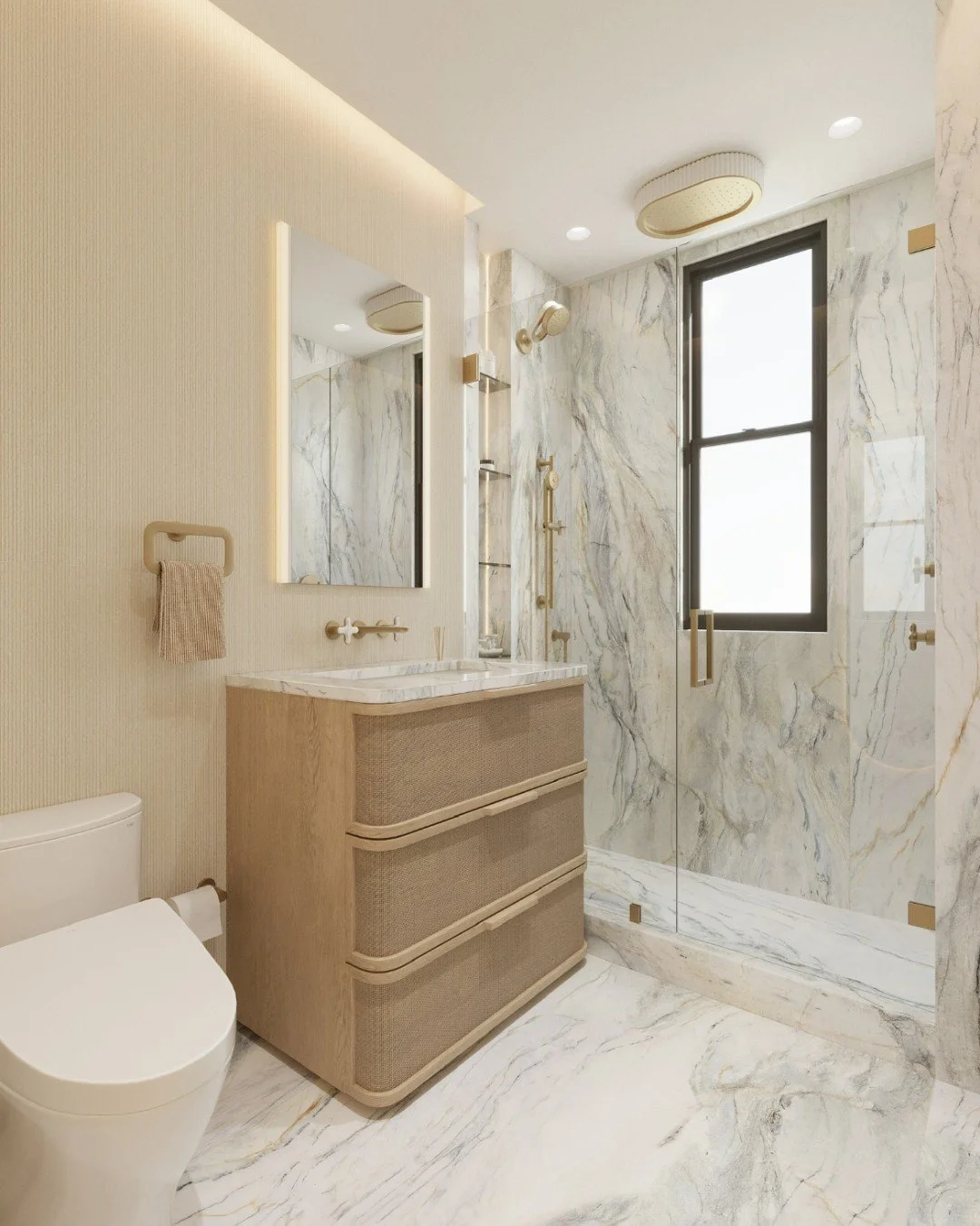 This primary bath design lends timeless materials with modern warmth &mdash; from the veined marble wrapping floor to ceiling in the shower, to the textured oak vanity that softens the space with natural texture. Brass accents and thoughtful lighting