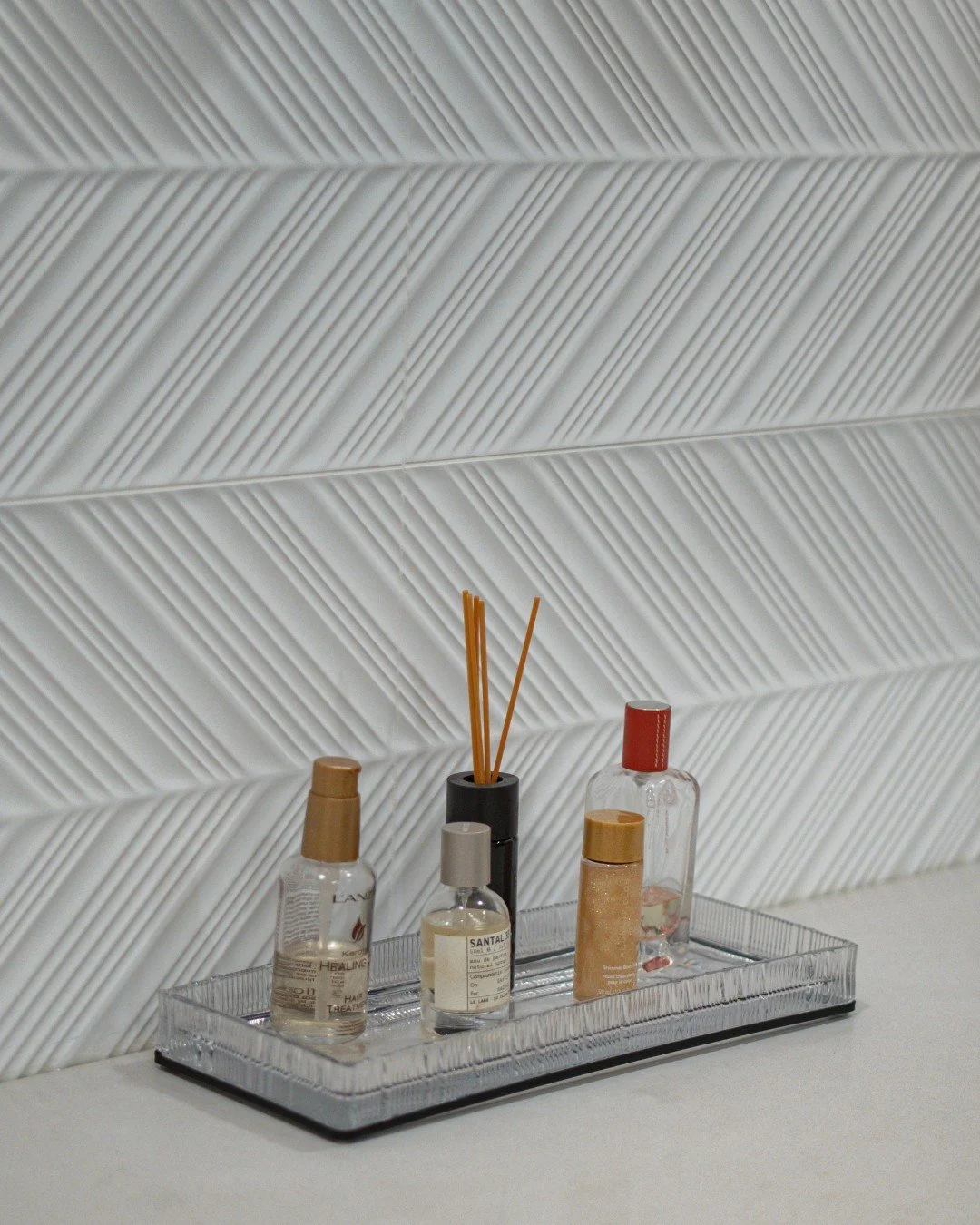 Texture takes center stage in this primary bathroom. ✨

We used Nemo Tile + Stone&rsquo;s Super White Spire Glossy 12x36 on the vanity wall to create a subtle focal moment&mdash;its raised geometric pattern catches the light, adding depth and movemen