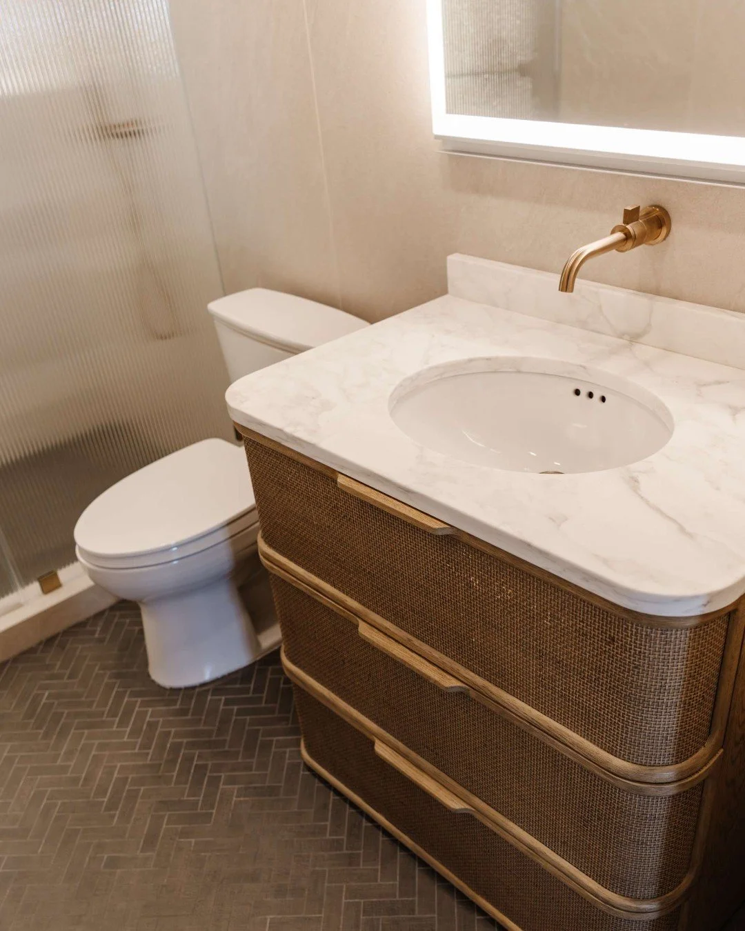 It&rsquo;s all in the perfect pairings 😍

This herringbone tile floor and rattan vanity complement each other in the most effortless way&mdash;adding depth, warmth, and a touch of natural elegance to the space.

When we design bathrooms, we look for
