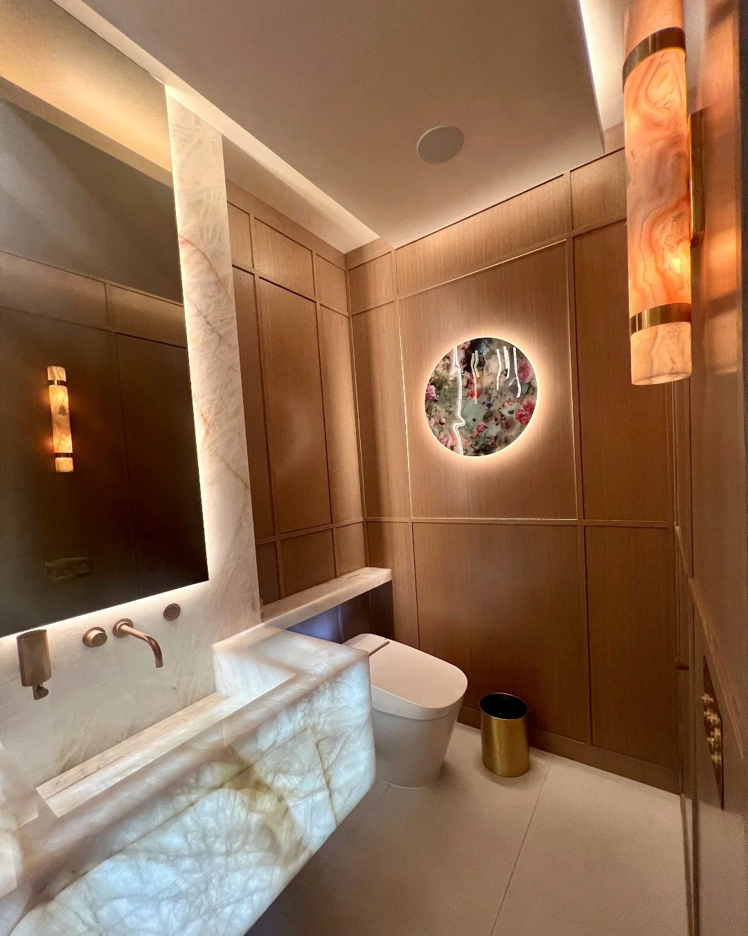 A bathroom that reveals more than meets the eye ✨

Warm wood paneling, sculptural lighting, and the natural luminosity of onyx come together to create a space that feels both calming and refined. Look a little closer and you&rsquo;ll find one of our 