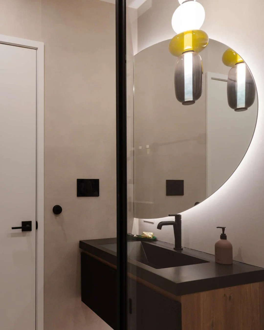 The details in this guest bath are all about intention.

Because this space is used only occasionally, we shifted the focus away from storage and toward creating a moment. Enter the custom half-moon mirror&mdash;an asymmetrical statement that immedia