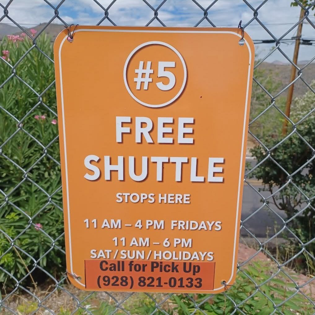 orange Free Shuttle sign with hours and phone number
