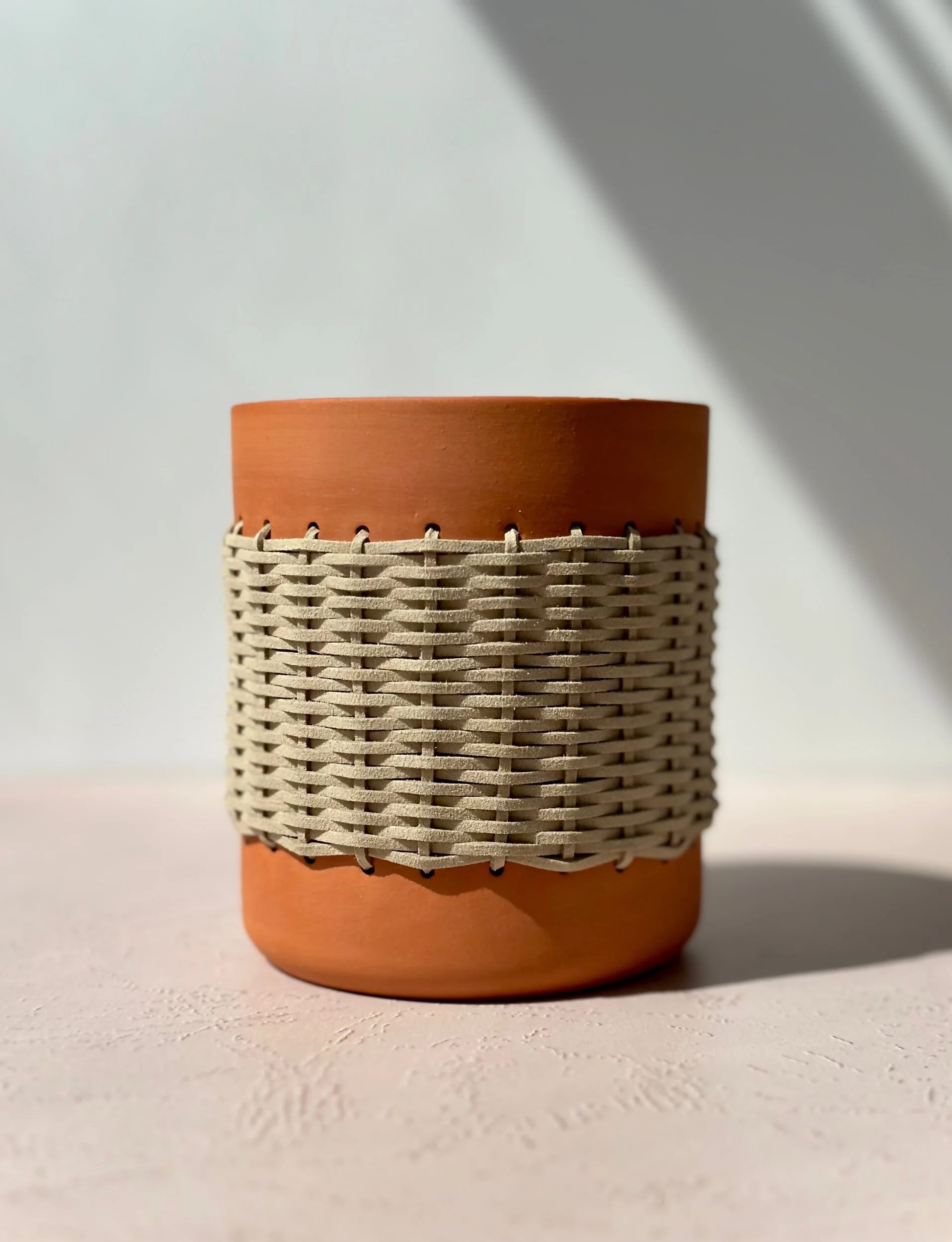 terracotta vase with faux swede woven around it