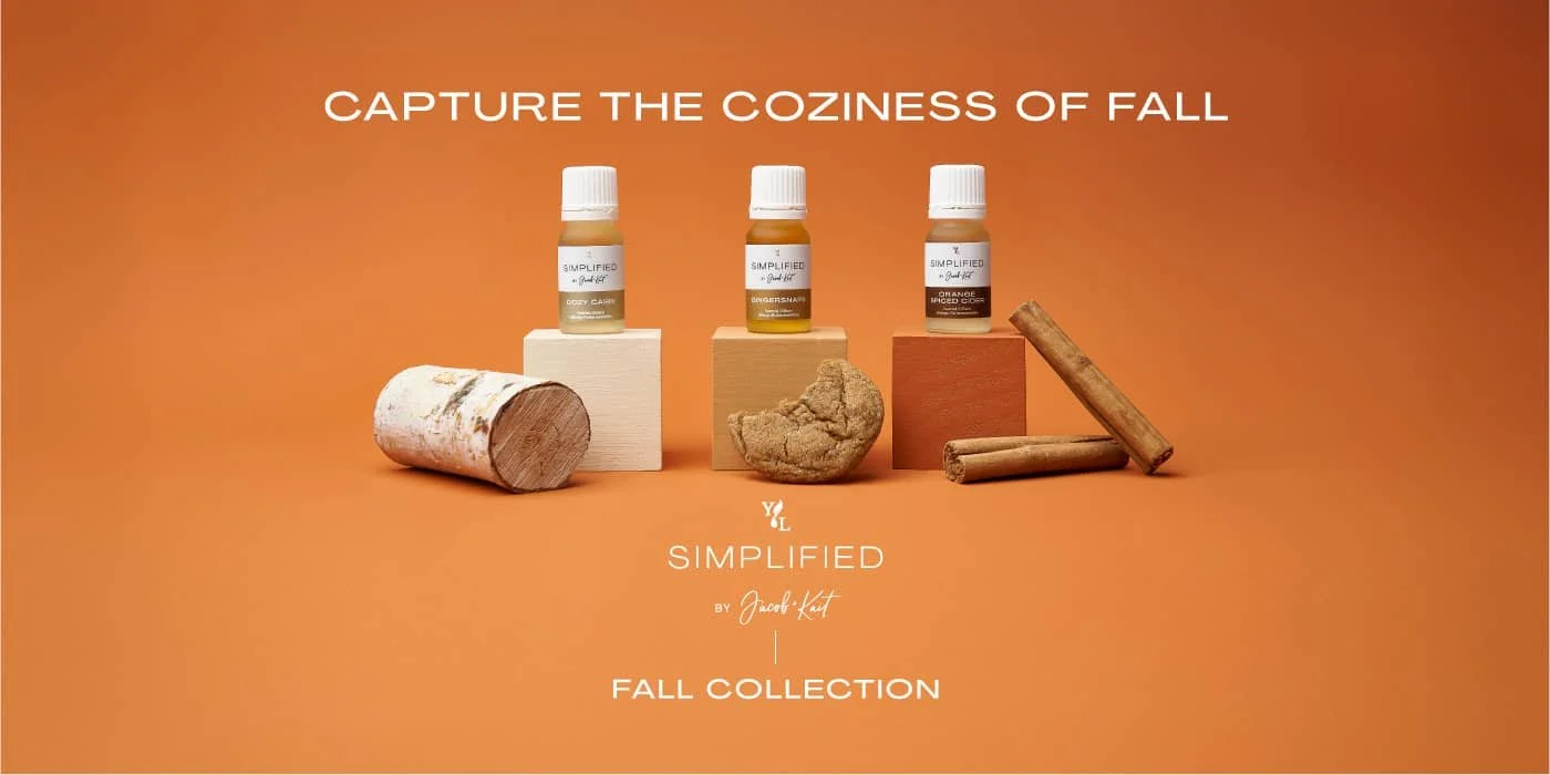 Young Living Simplified Fall Collection essential oils displayed with cozy fall props on a warm orange background