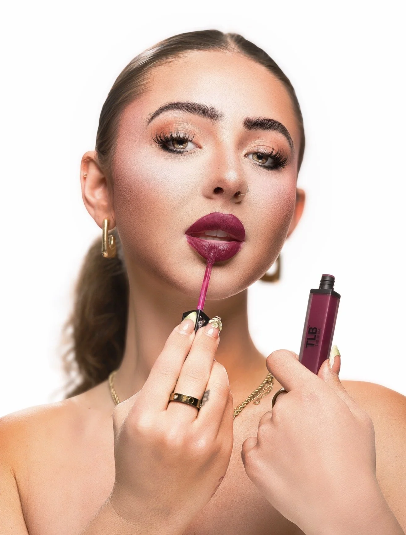 A woman applying deep magenta lipstick in front of a white background. Cleveland Photographer. Cleveland Portrait Photographer