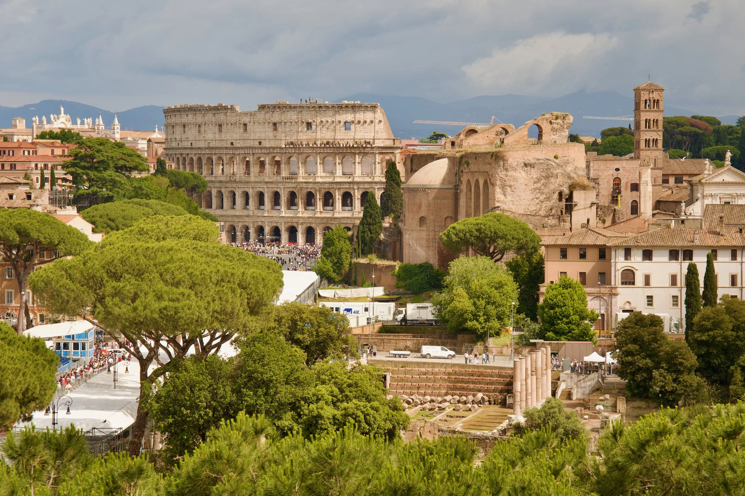 distance view of the colosseum with trees in the foreground