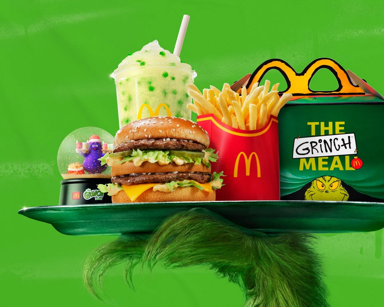 McDonald's Grinch  "I'm ruinin' it!"  Out of home campaign with Wieden+Kennedy. McDonald's big Mac meal with fries, a green Grinch drink, a Grinch-themed Grimace snow globe, and a Grinch-themed Happy Meal box, all balanced on a  tray held by Grinches