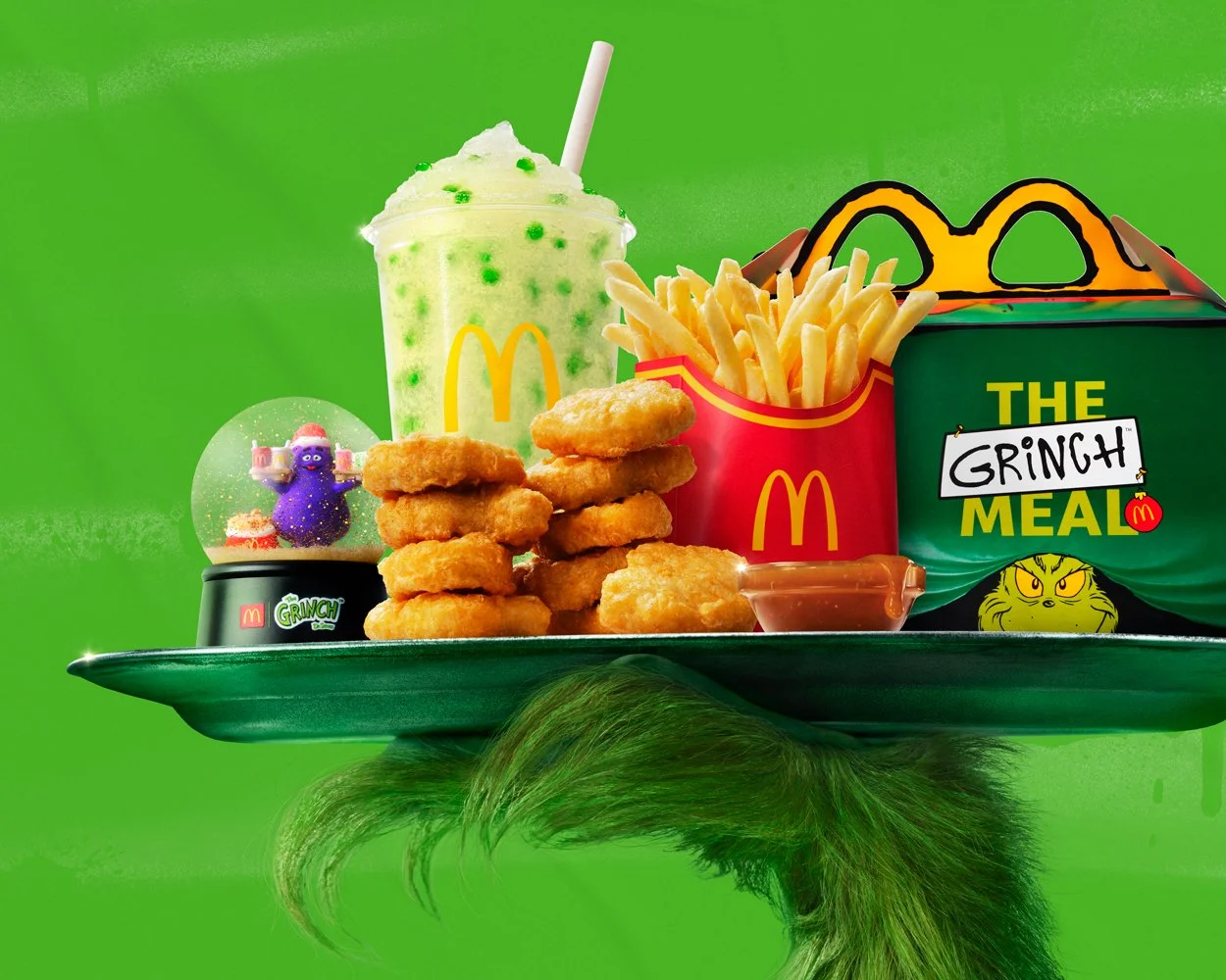 McDonald's Grinch  "I'm ruinin' it!"  Out of home campaign with Wieden+Kennedy. The Grinch meal with chicken nuggets, French fries, a green soda, and a Grinch-themed toy Grimace, all on a tray against a green background with a Grinch holding it