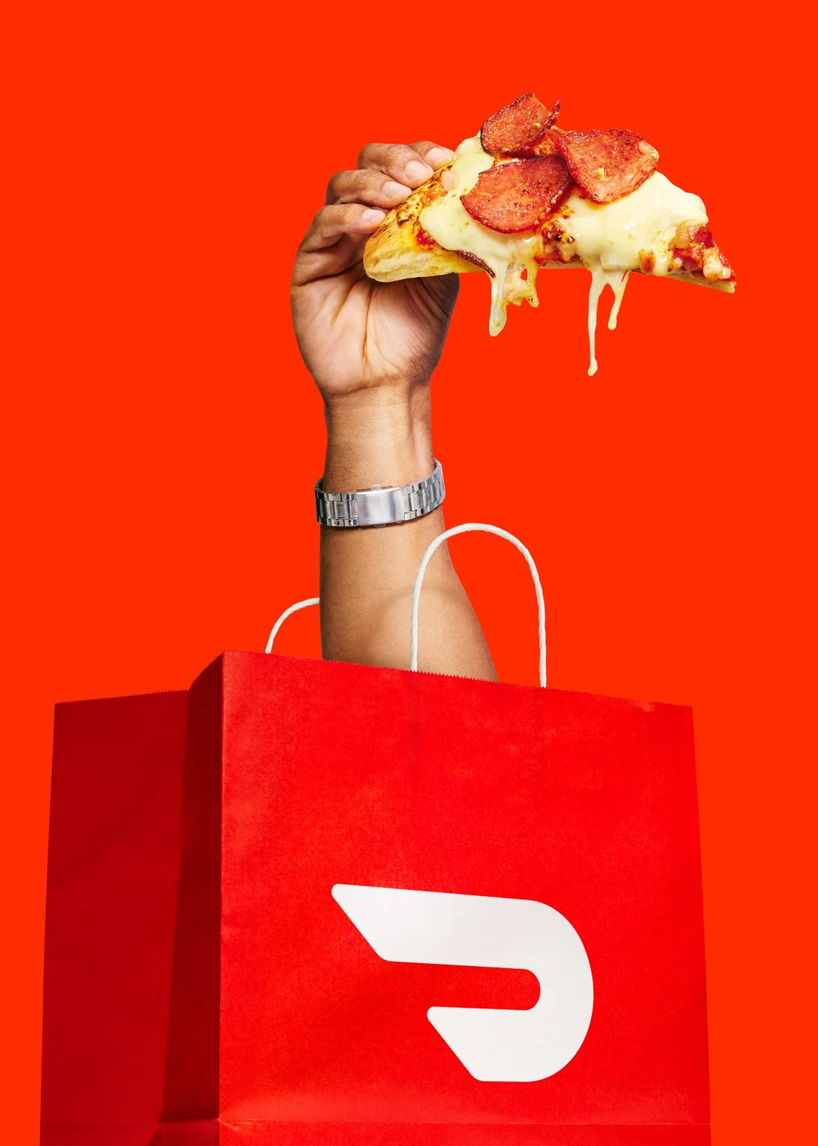 Doordash advertising campaign ''smash it''.  A hand holding a slice of pepperoni pizza above a red shopping bag against a red background.