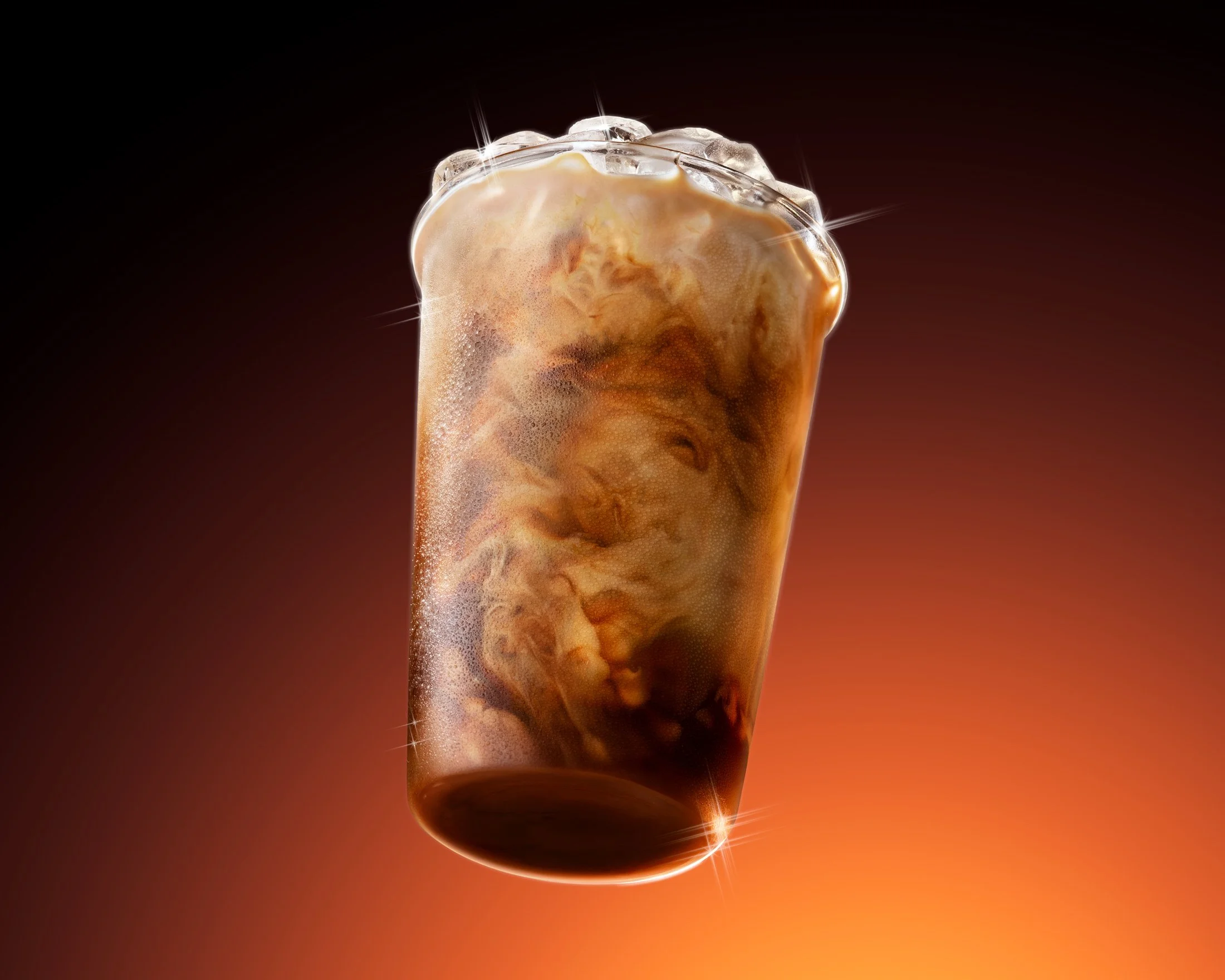 McDonald's McCafe "You Deserve a Little Treat" Out of home campaign with Wieden+Kennedy. A close-up of a cold, foamy glass of iced latte against a dark and orange gradient background.