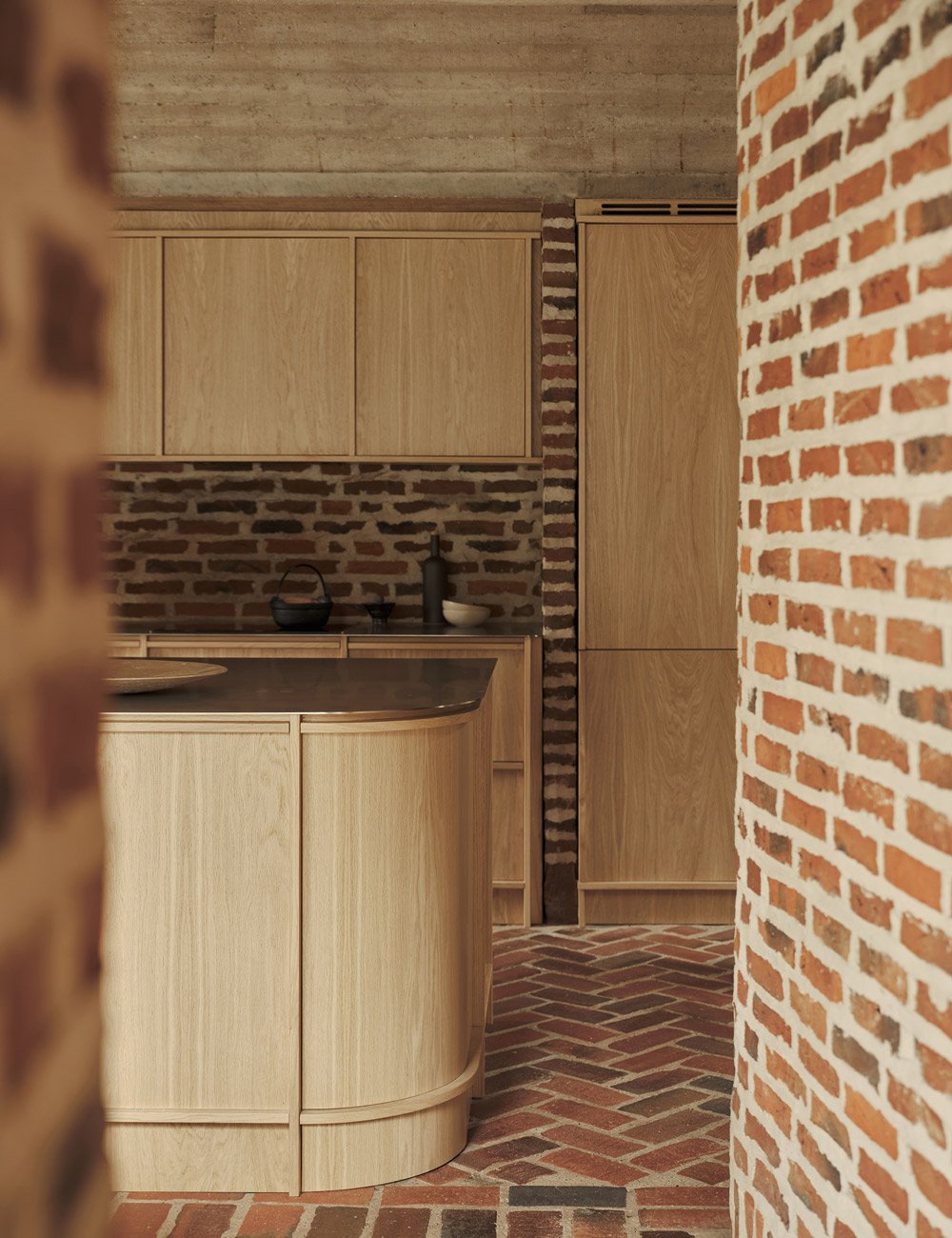 Specialbygget køkkenø i egetræ i et arkitekttegnet hus.