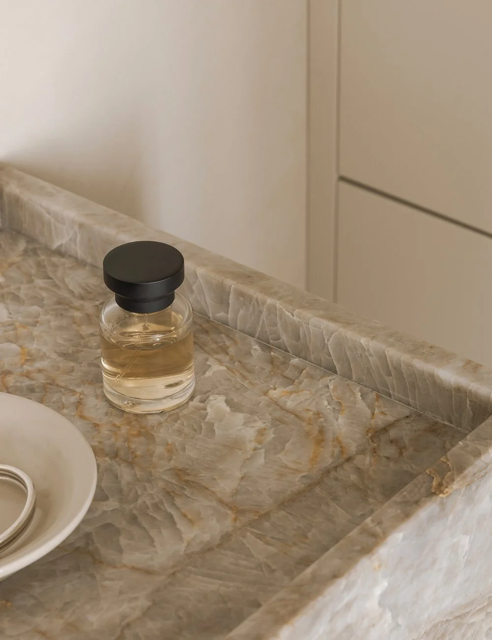 Håndvask i Taj Mahal-kvartsit med nuancer af rav, beige og blød hvid, der tilfører varme til det minimalistiske badeværelse.