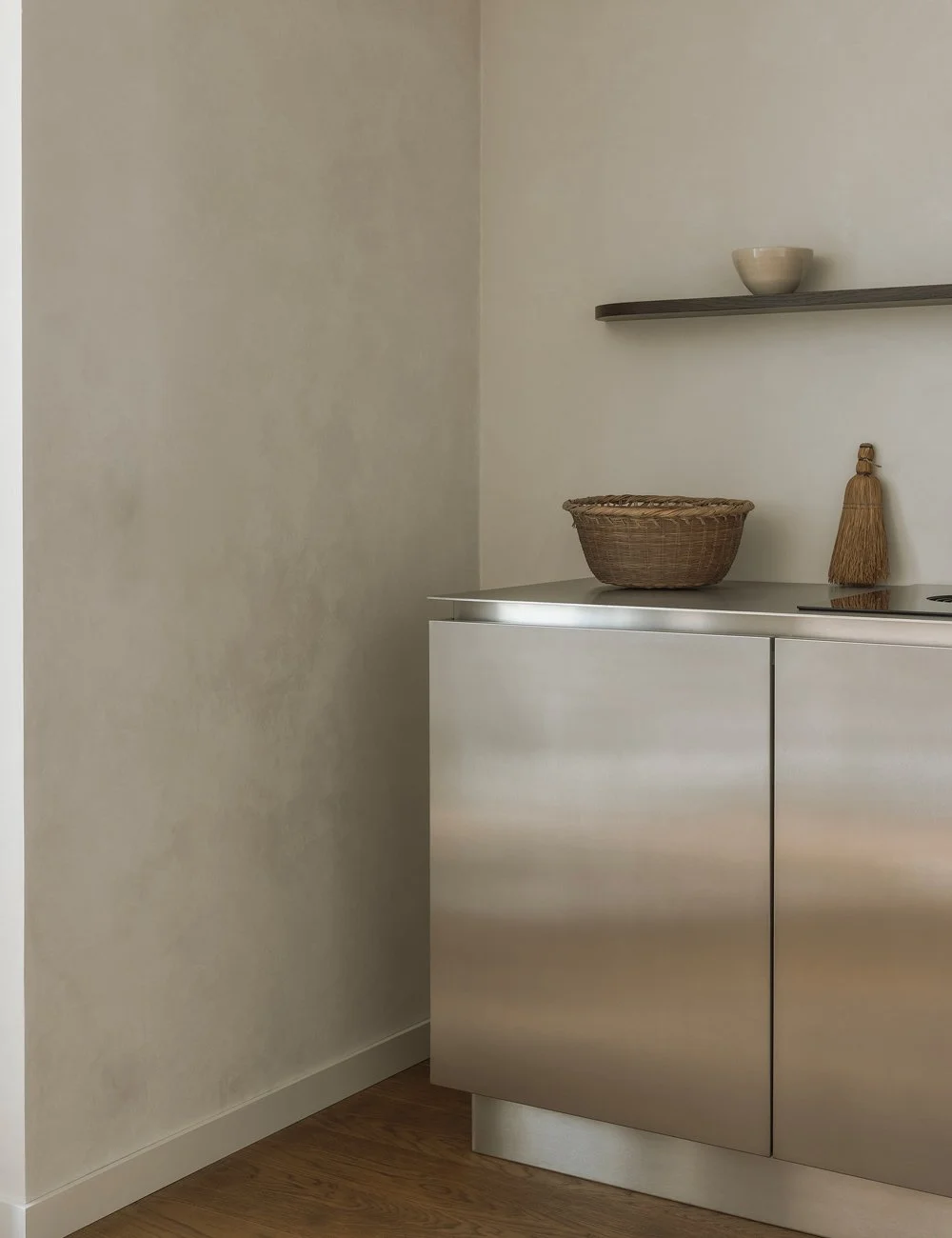 Køkkenskab med køkkenfronter i rustfrit stål med skjulte greb i et minimalistisk køkken.