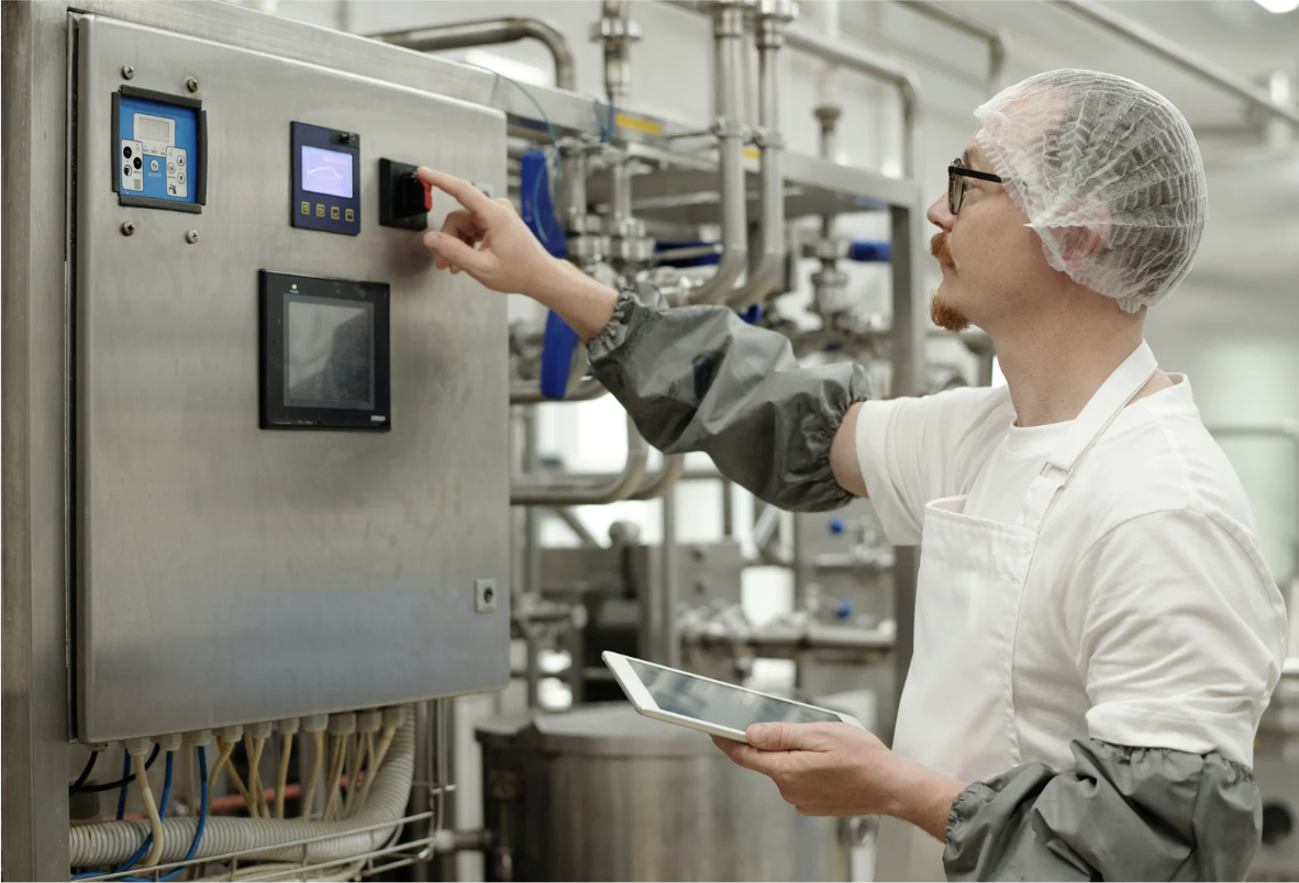 Plant operator adjusting moisture and temperature settings on food drying system control panel