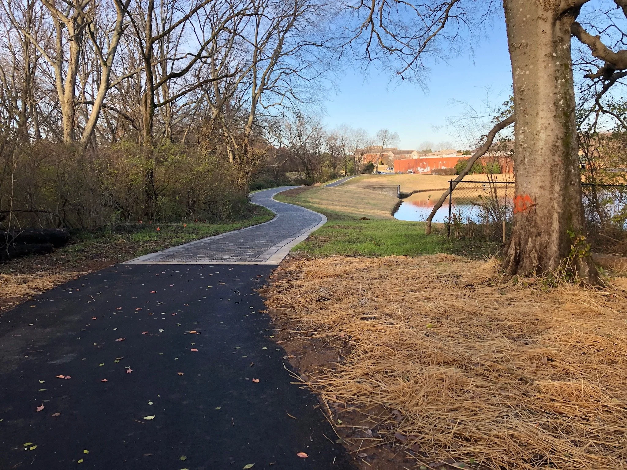 A walking trail created for the City of Brentwood TN in Williamson County Tennessee using asphalt, pavers, stone, and included the grading required to form this asphalt pedestrian walking path and trail