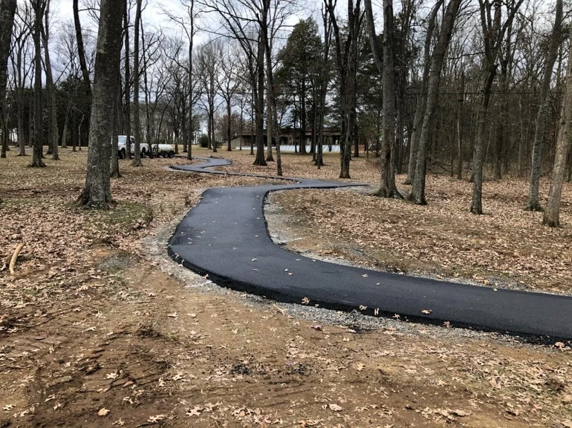 Paving of an asphalt walking path in Rockland Recreational Area for a trail in Sumner County Tennessee in Hendersonville, TN using a paver, for pedestrian recreation use