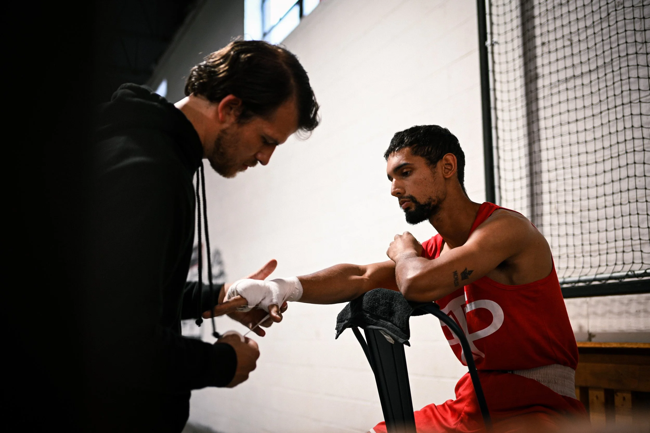Coach Damien wrapping the hands of his boxer before his boxing match