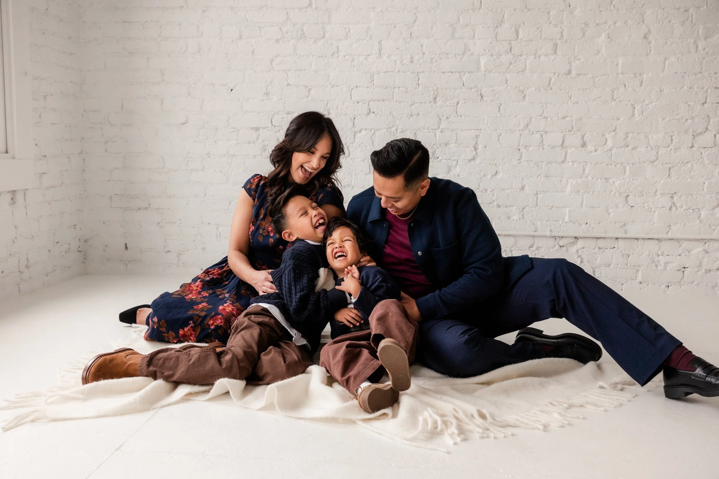 Mom and dad tickle their sons with a natural light studio backdrop