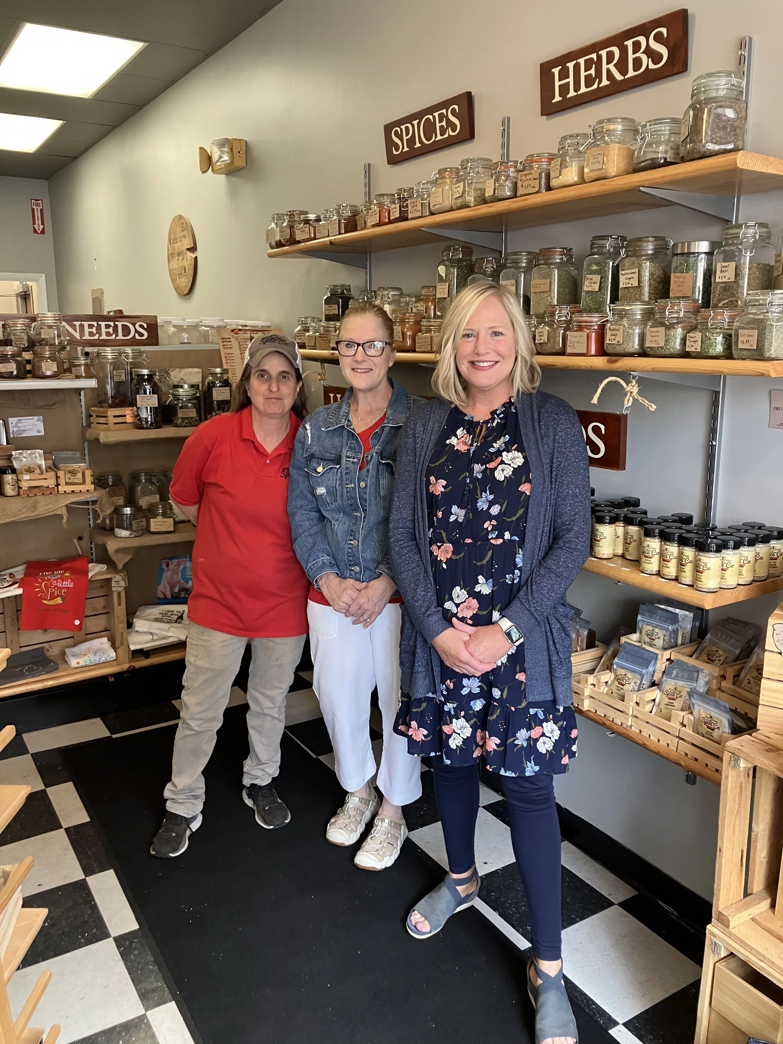 Three women pose in a shop that sells spices in Manistee, Michigan