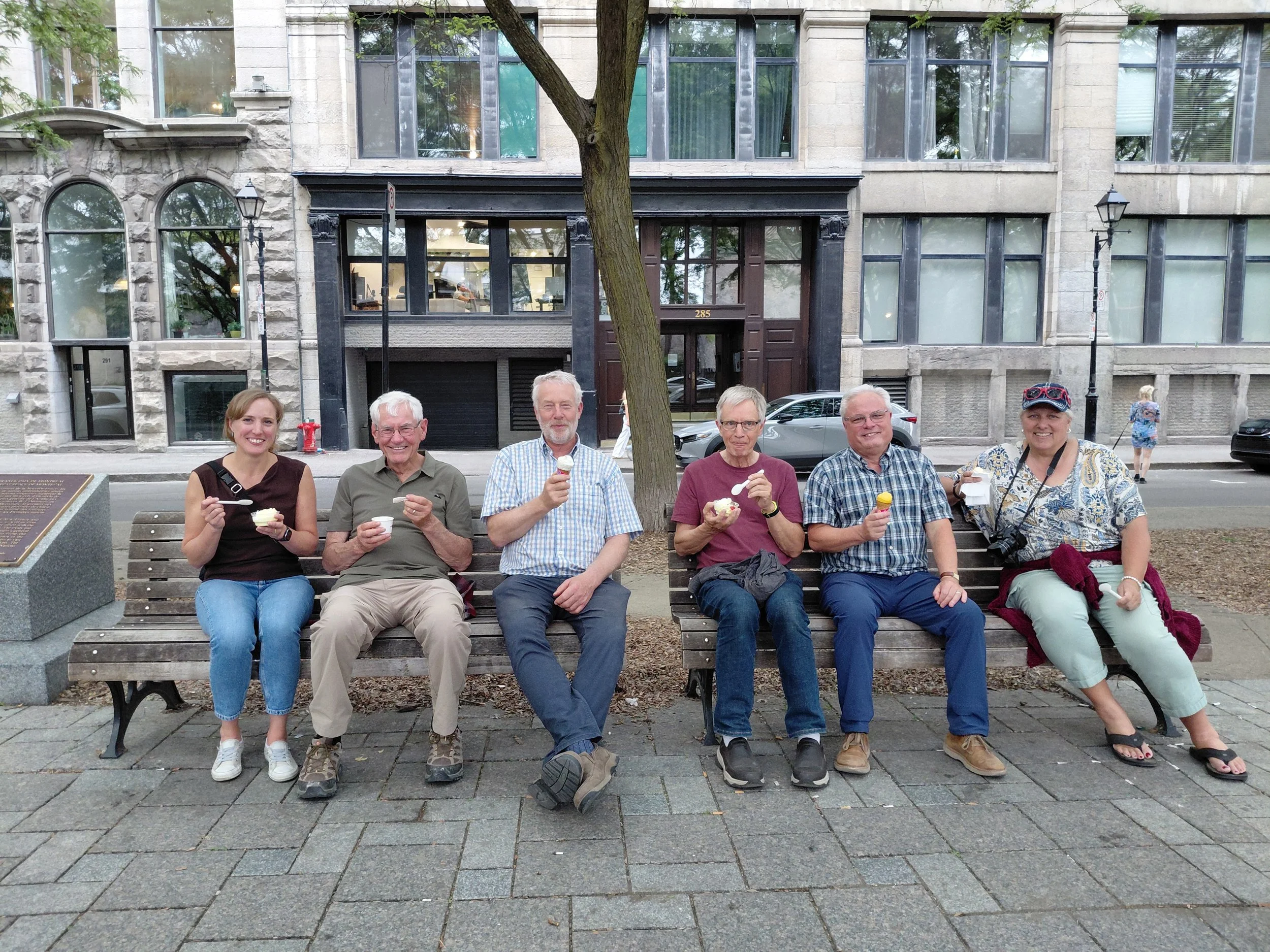 des gens assis sur un banc en train de manger une glace