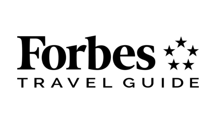 Forbes Travel Guide logo with black and white text and seven stars arranged in a circular pattern.