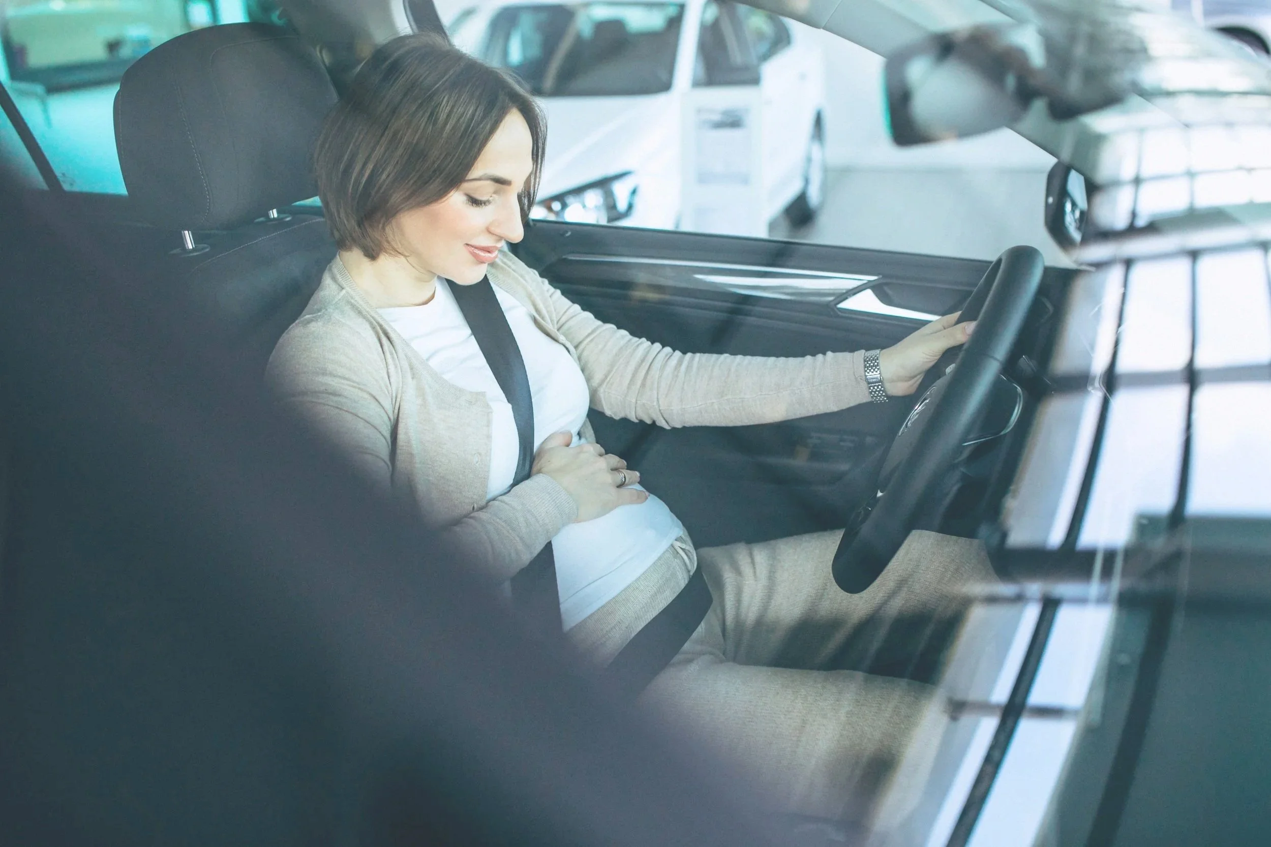 Southern California night nurse, car seat tech and doula teaching a pregnant mom how to use her seat belt safely during pregnancy