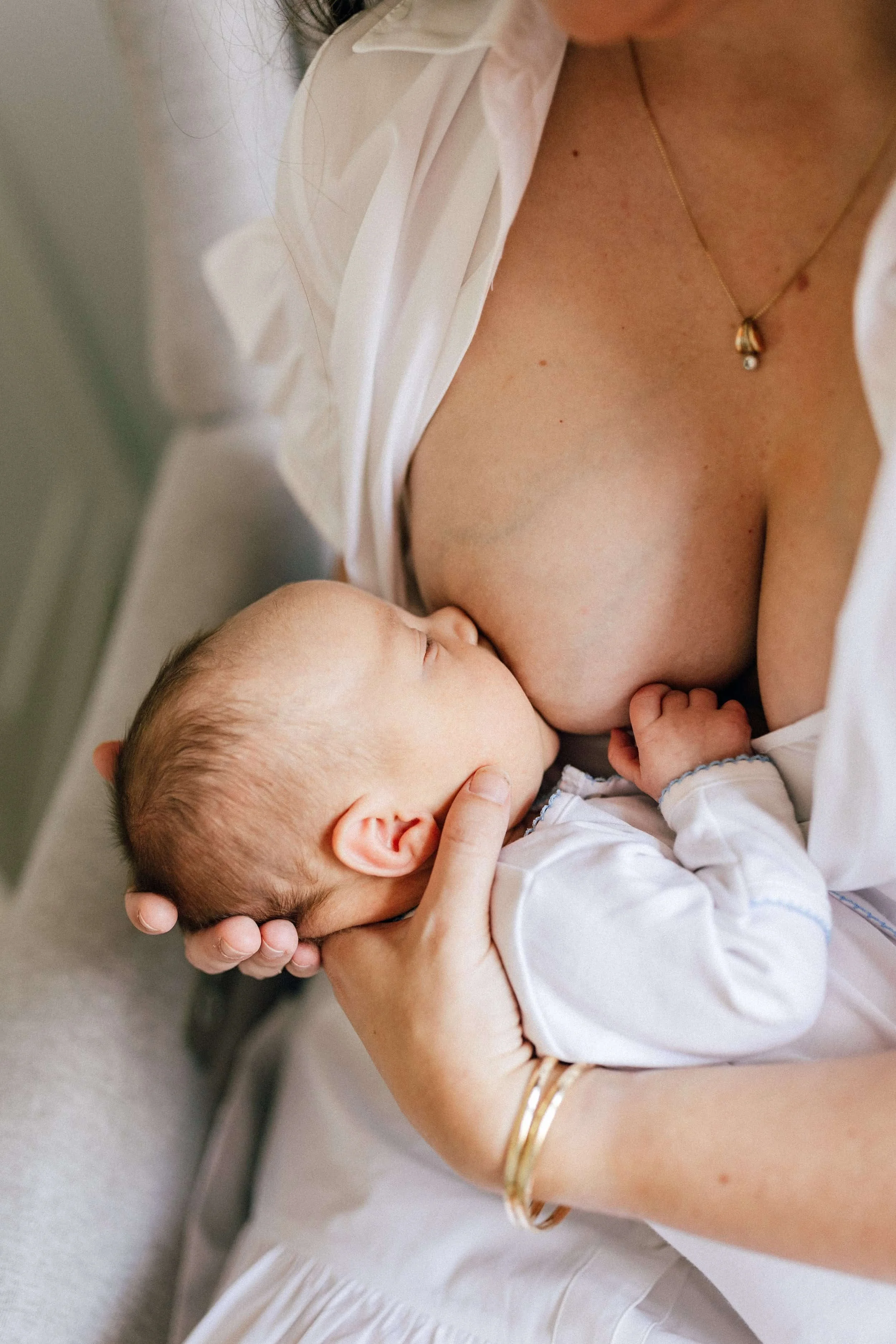 Woman holding baby to breast - breastfeeding and lactation support