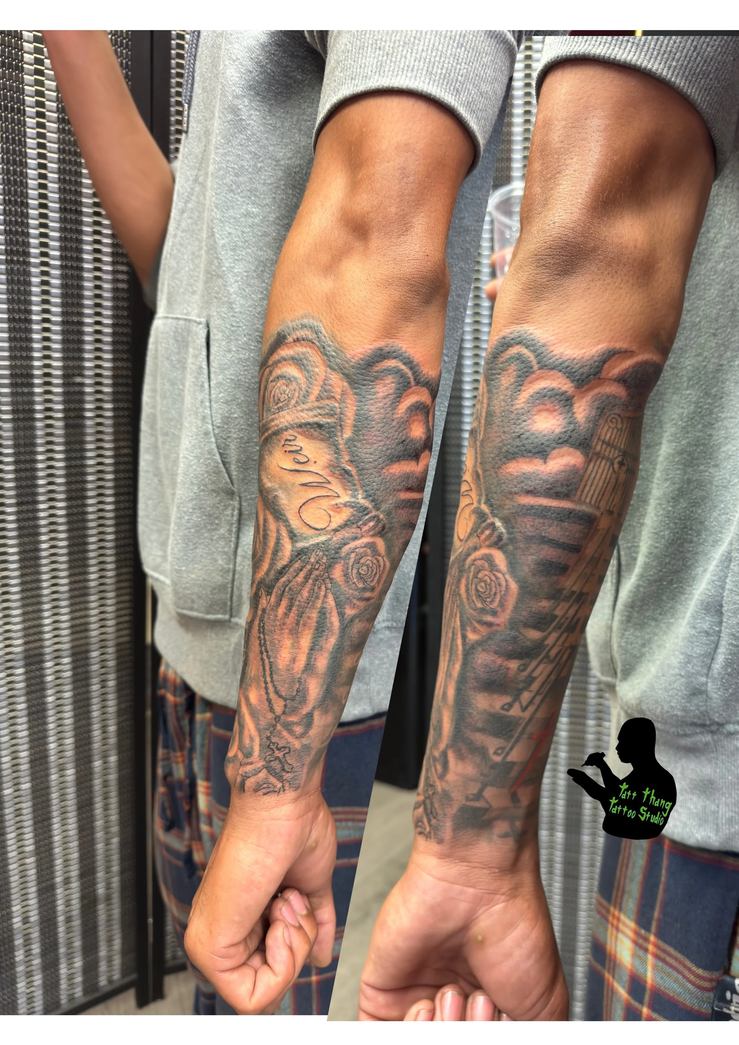 Tattooed arm with image of a praying hand, roses, and clouds.