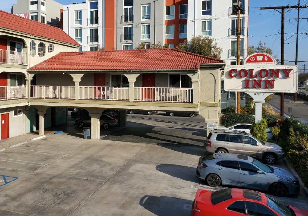 Exterior view of Colony Inn North Hollywood with parking lot, red-tiled roof, and visible hotel sign at 4917 Vineland Ave, Los Angeles