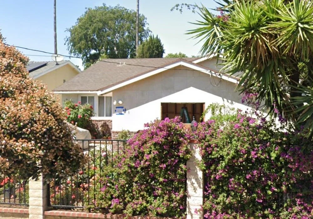 Exterior view of Angels Hands Senior Living, a residential assisted living home with landscaped garden and palm trees