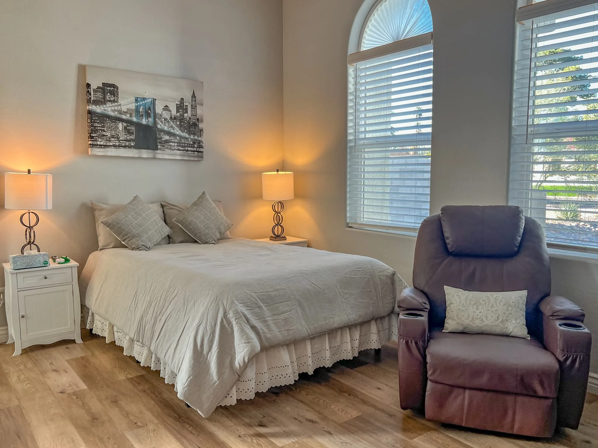 Private resident bedroom at Serendipity in the Sun in Scottsdale, featuring a cozy bed, recliner, and natural lighting—offering a homelike environment in assisted living.