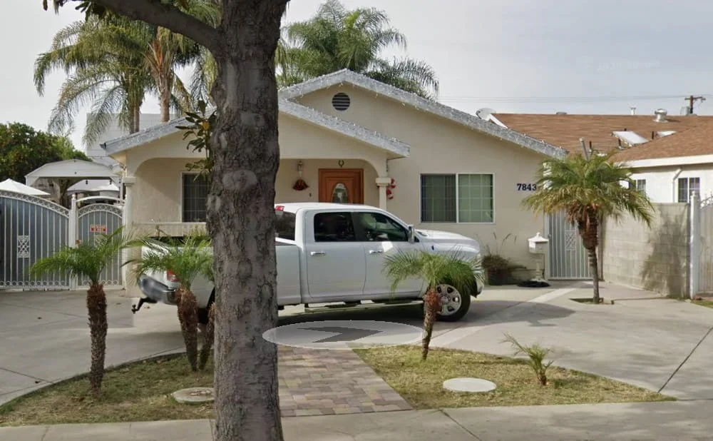 Single-story residential care home at 7843 Stansbury Ave in Panorama City, with a white pickup truck parked in the driveway and palm trees in front.