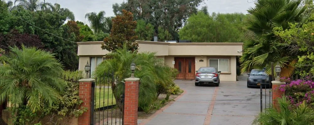Exterior view of Be Well Senior Living II Inc., a residential assisted living home surrounded by greenery