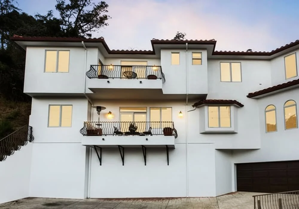 Modern Mediterranean-style villa in the hills of Studio City, California, with balconies, warm lighting, and a terracotta roof.
