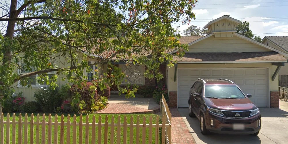 The exterior of Dependable Overnight Care, Inc., a residential senior care home featuring a peaceful front yard and picket fence, where residents can easily facilitate a doctor appointment in Van Nuys via on-site medical house calls.