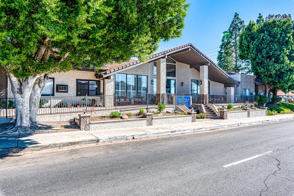 Front view of Northridge Valley Senior Living featuring a modern sloped-roof entrance, landscaped walkway, and mature trees, reflecting a welcoming and well-maintained assisted living environment.