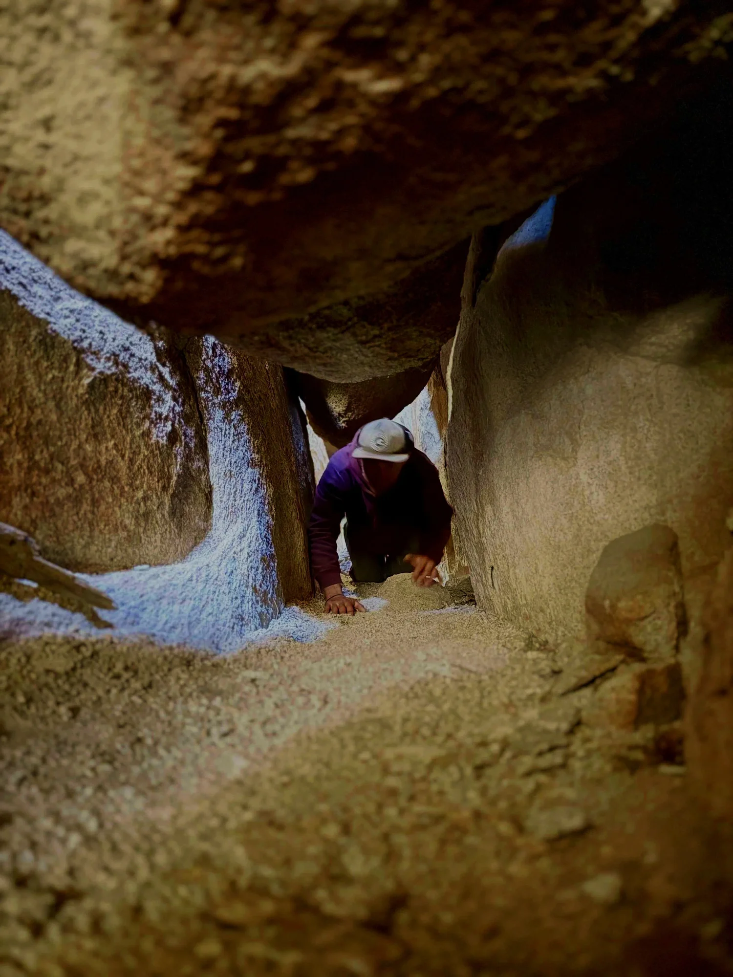 A guest crawling through a tight narrow passage on The Great Misdirect exclusive exploration route