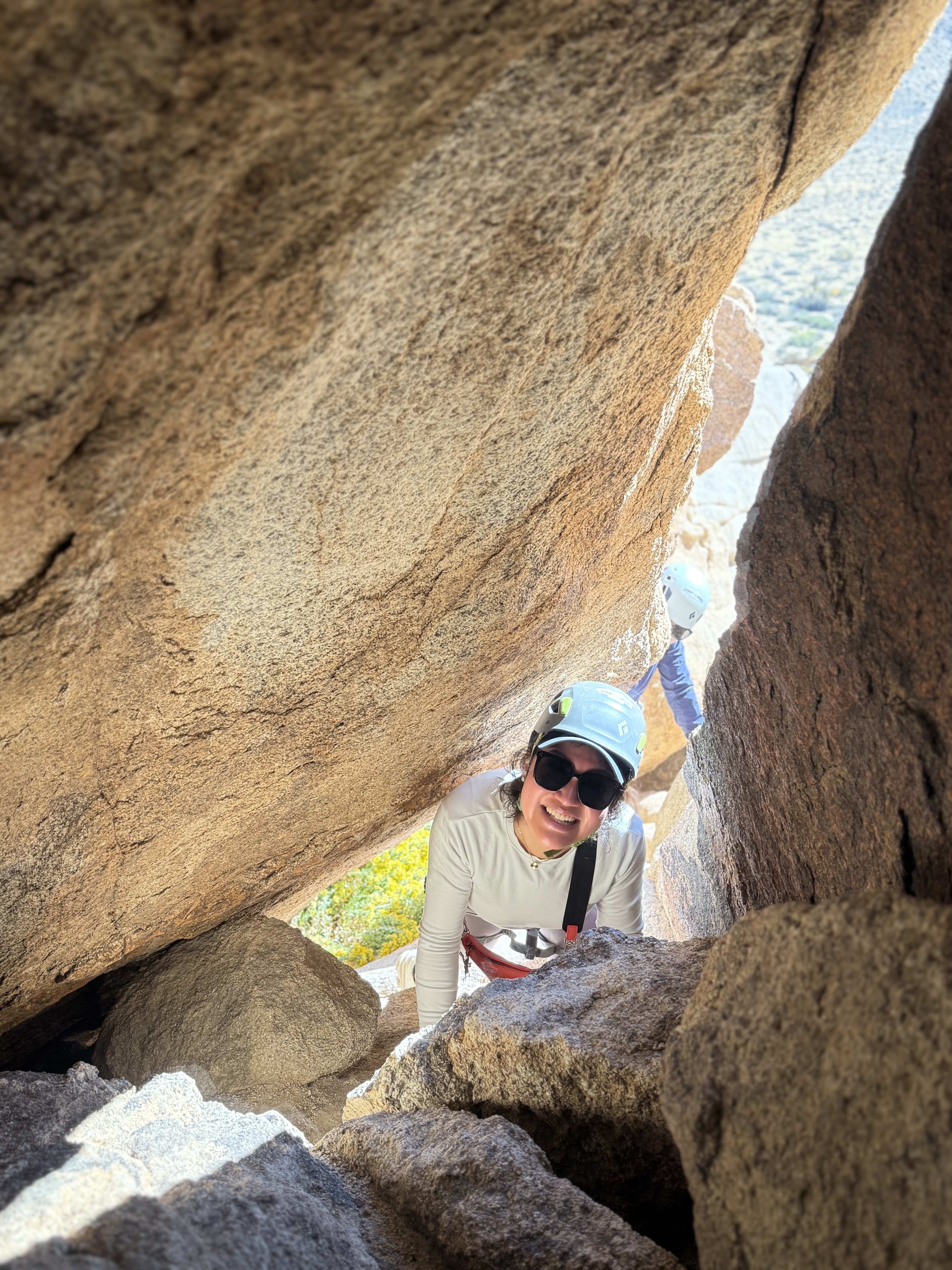 Summit_Climbing_Guides_Joshua_Tree_Guides_Adventure_Routes_Woman_Looking_Through_Cave.jpg