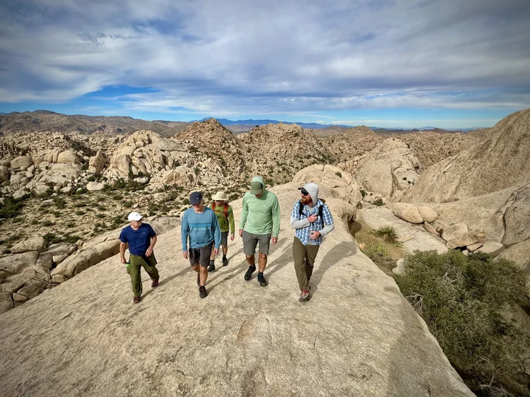 Hikers navigating a granite ridge in Joshua Tree