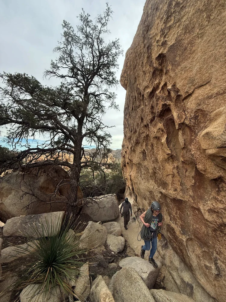 Climber scrambling toward a granite traverse