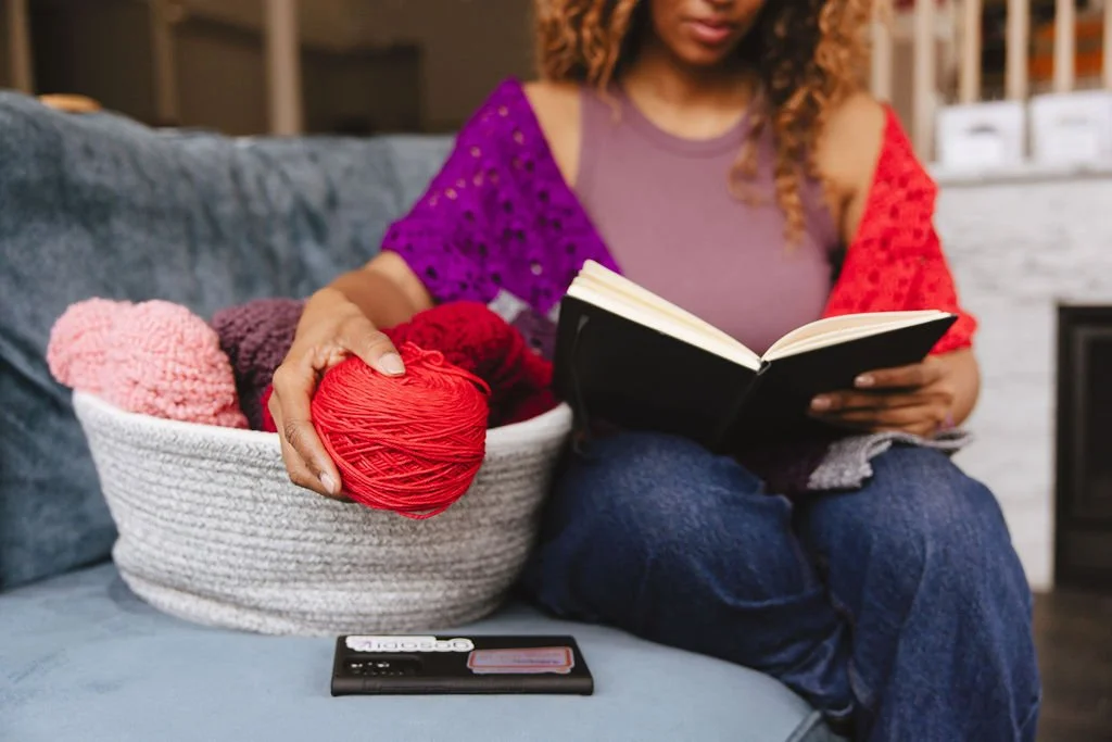 Woman holding ball of yarn and notebook