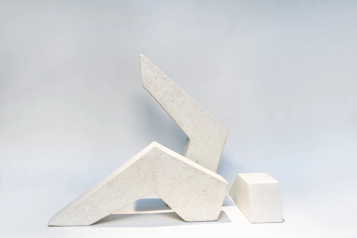 Three pieces of concrete and beeswax that resemble legs
