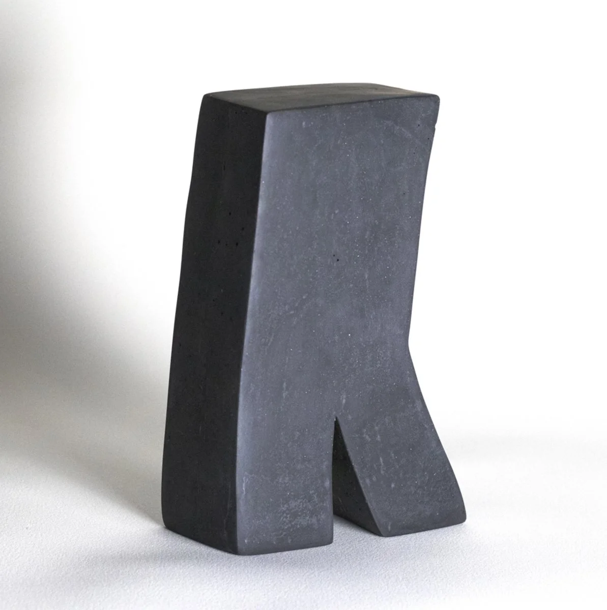 Small dark grey sculpture with plaster, iron oxide, and beeswax