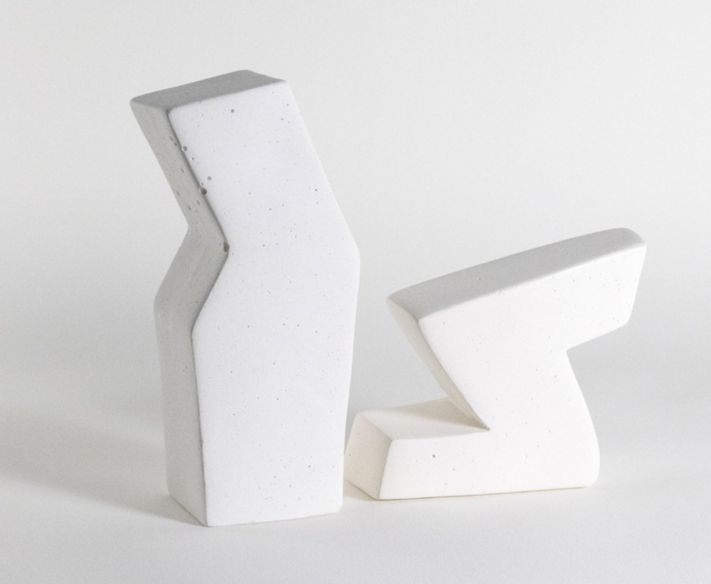 Two white sculptures made from plaster, pigment, and beeswax
